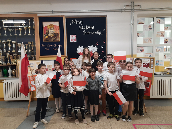 Grafika ilustrująca uczniów z biało-czerwonymi flagami