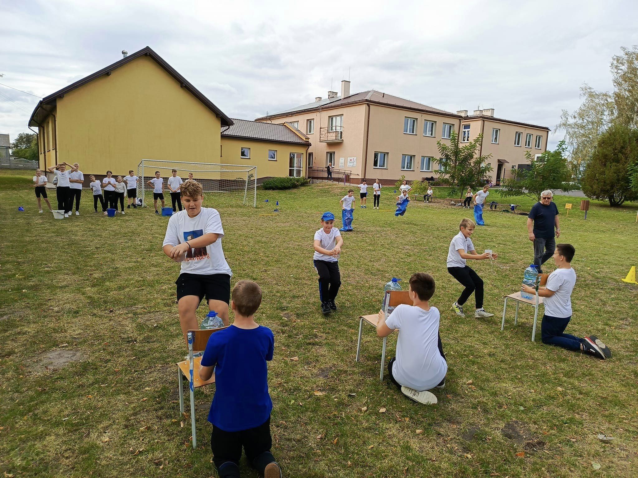 Uczniowie klas starszych podczas wyścigu ze szklankami wypełnionymi wodą