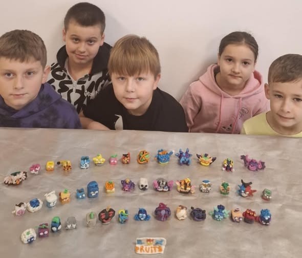 Pięcioro uczniów przy stoliku, przed nimi kolekcja figurek z plasteliny