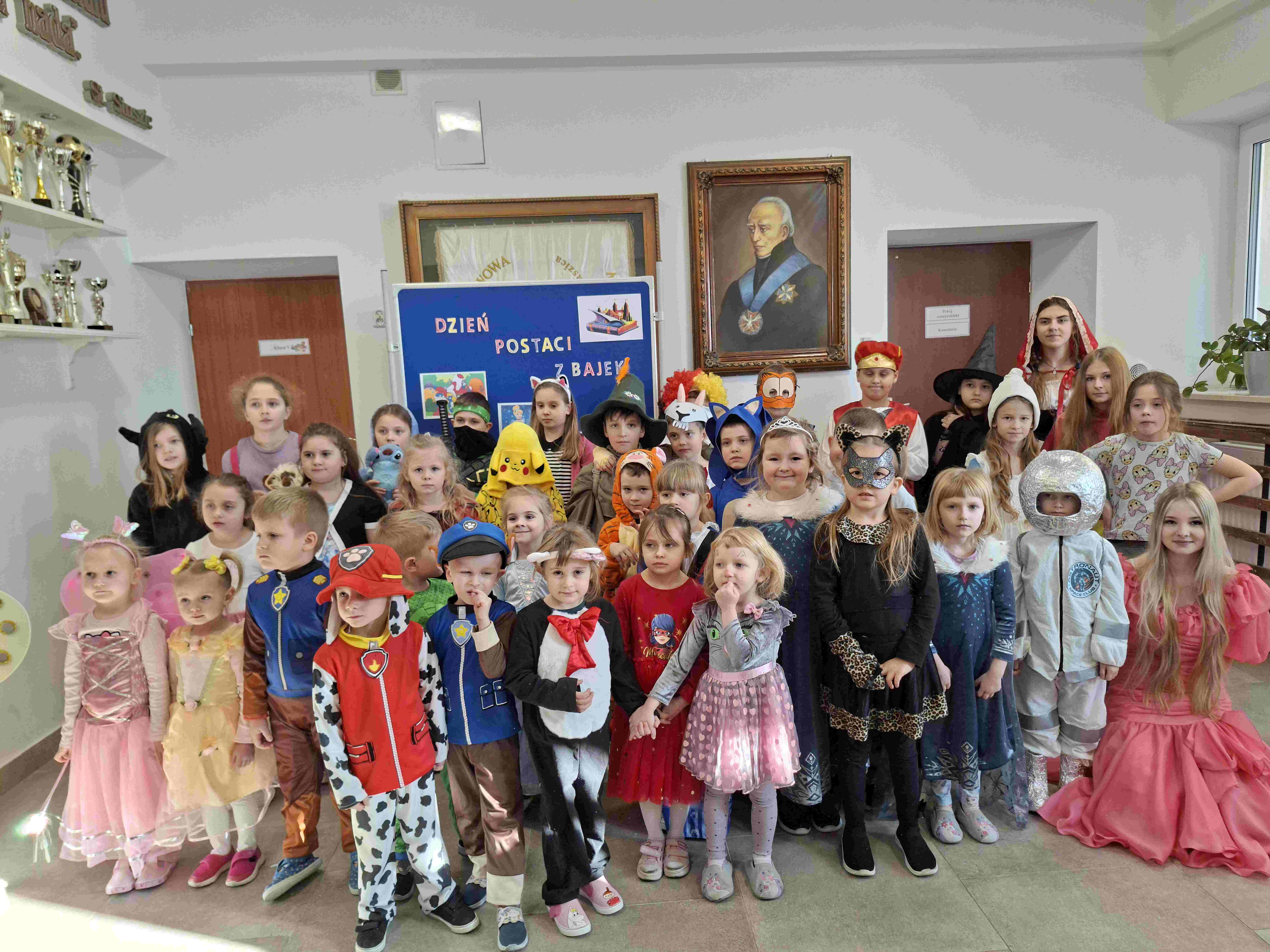 Dzieci z oddziałów przedszkolnych i klas młodszych w kolorowych przebraniach na wspólnej pamiątkowej fotografii