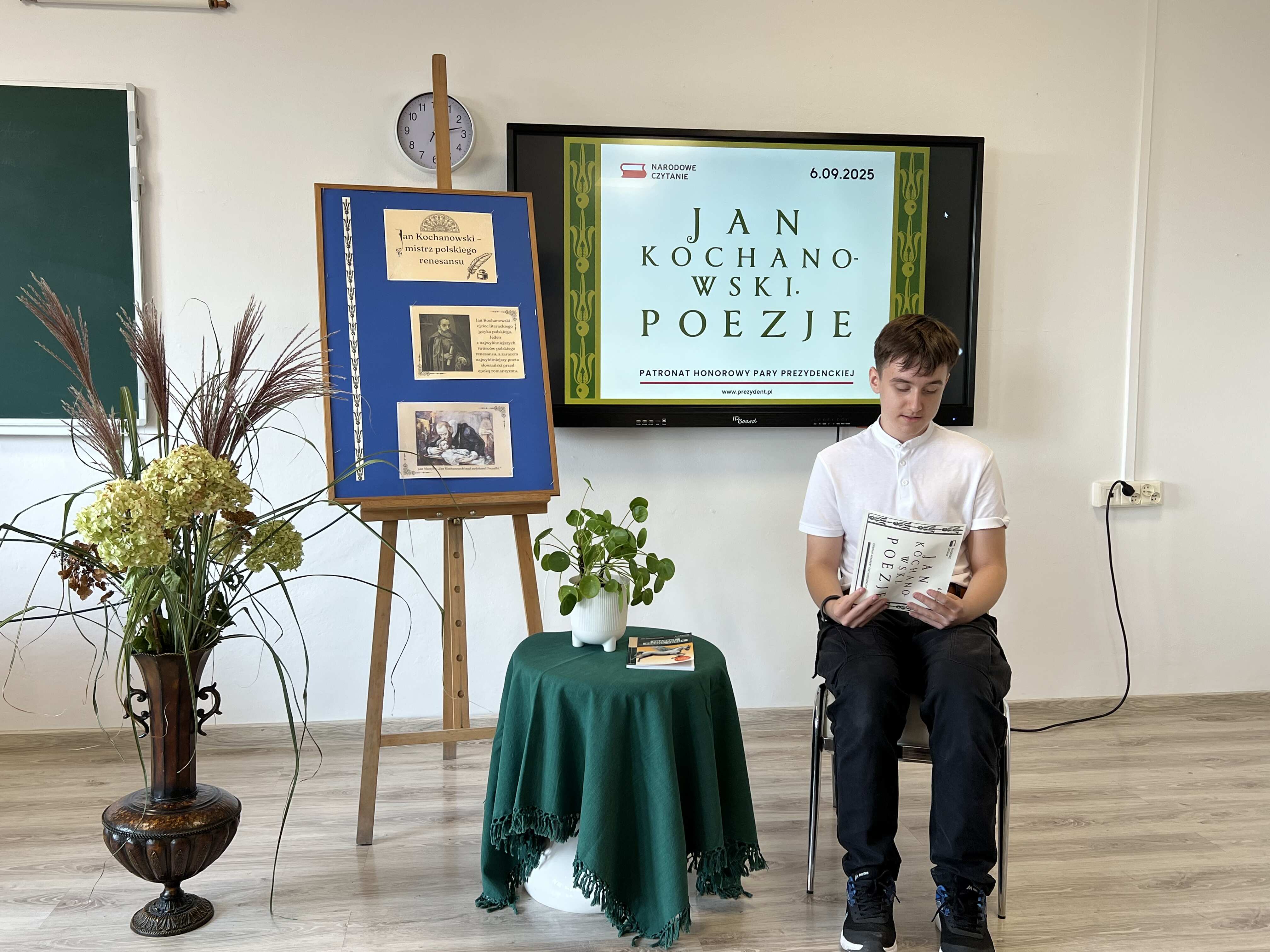 Uczeń czyta poezję na tle dekoracji okolicznościowej