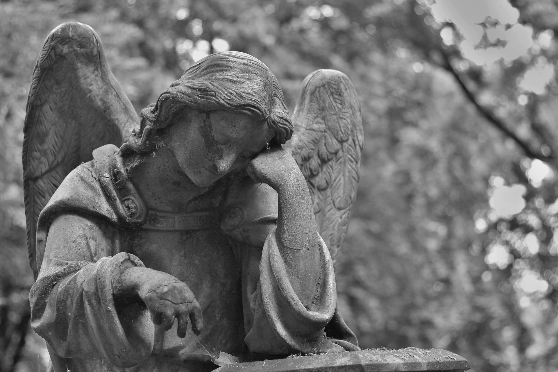 Czarno-białe zdjęcie rzeźby przedstawiającej płaczącego anioła
