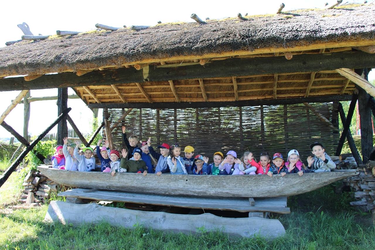 Dzieci przy drewnianej łodzi gockiej