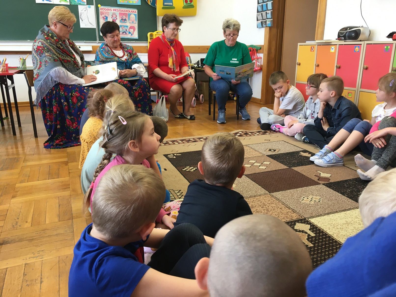 Dzieci słuchają bajkę „ Brzydkie kaczątko”,  czytaną przez panią z KGW w Cichobórzu