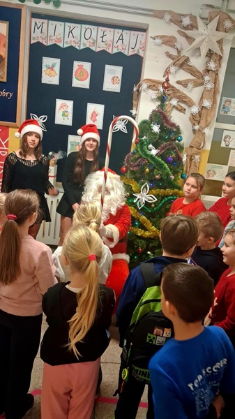 Grafika ilustrująca uczniów z mikołajem