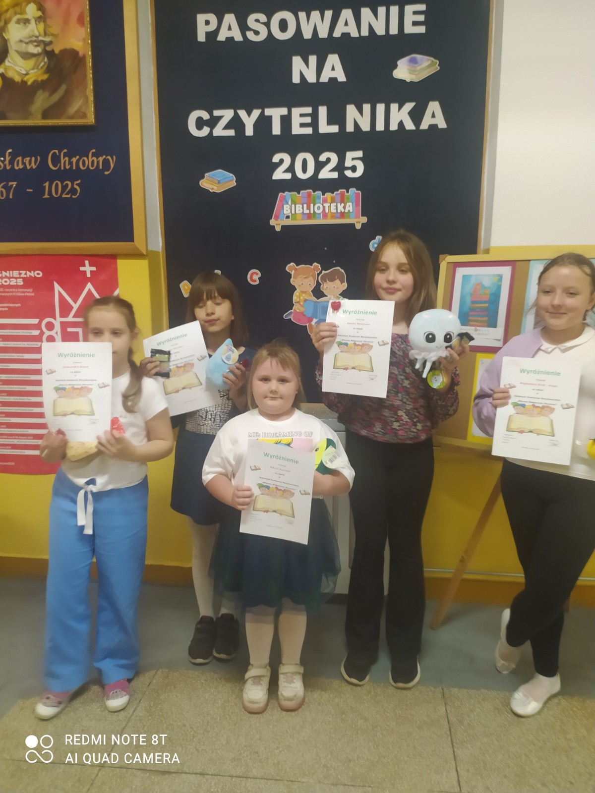 Uczniowie prezentują się z dyplomami otrzymanymi za prezentację wierszy.
