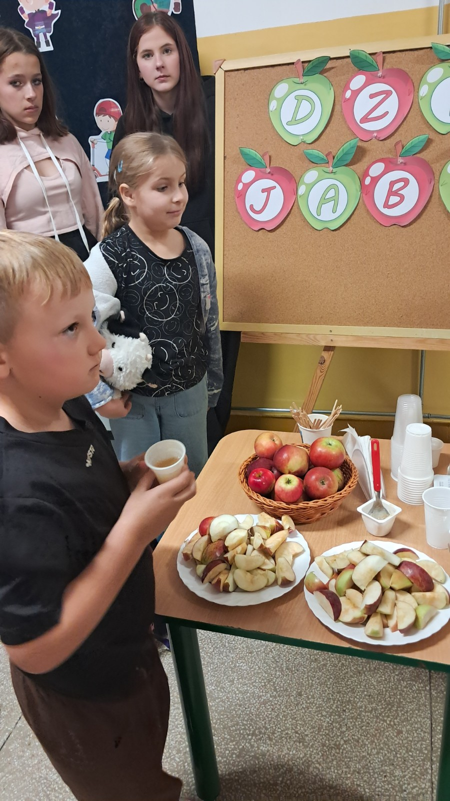 Dzieci degustują jabłka i sok z jabłek.