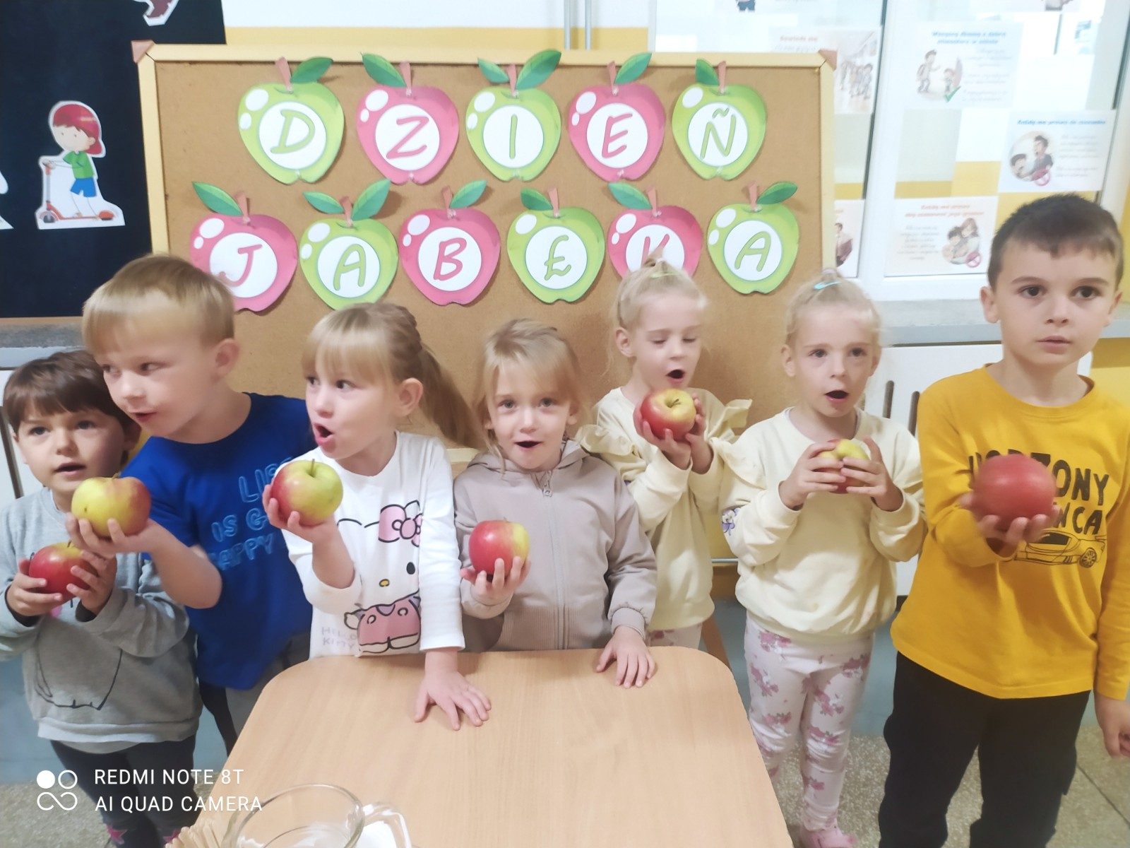 Dzieci pozują do zdjęcia przy stole.
