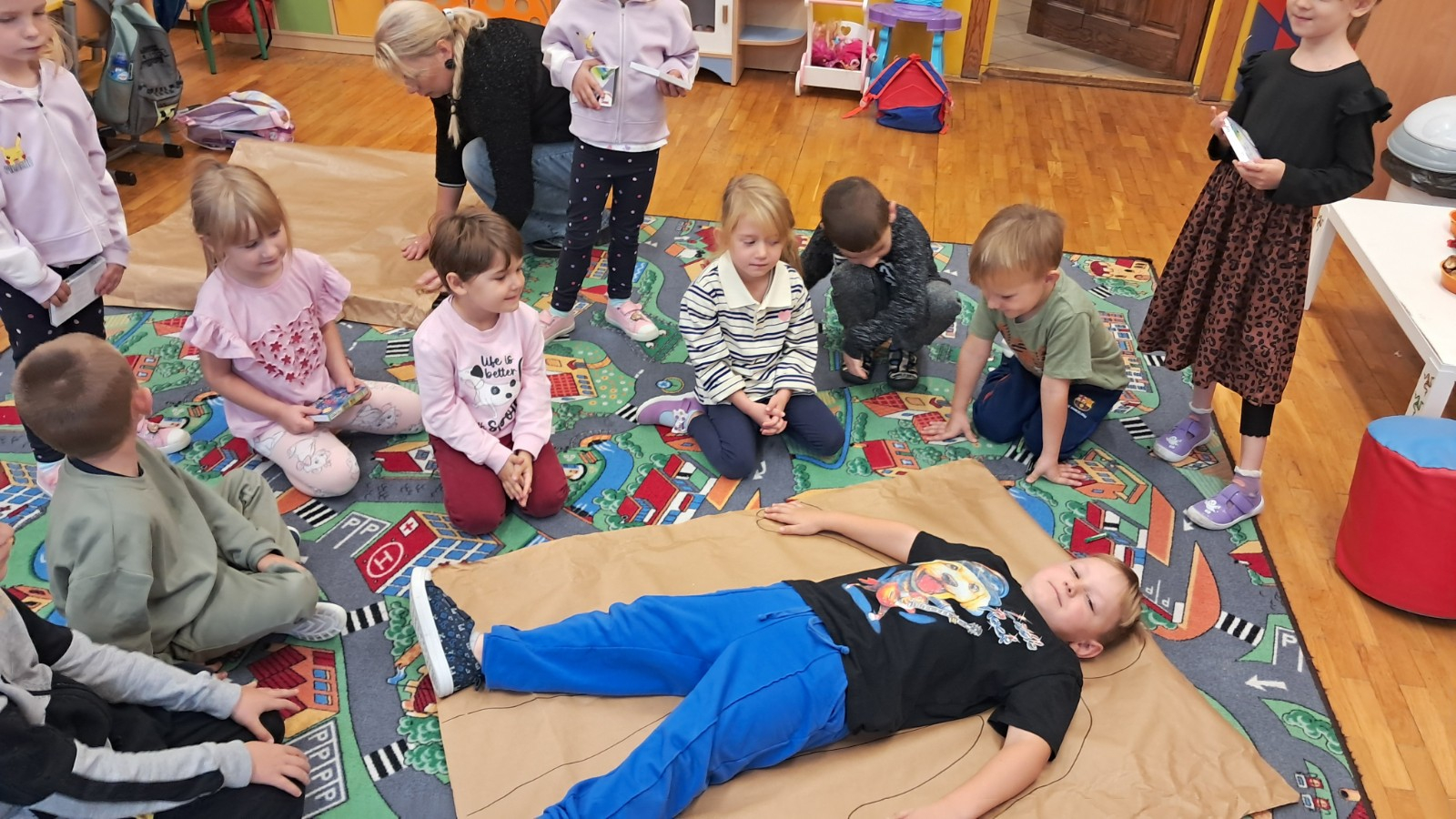 Dzieci odrysowują postać chłopca, a potem kolorują.