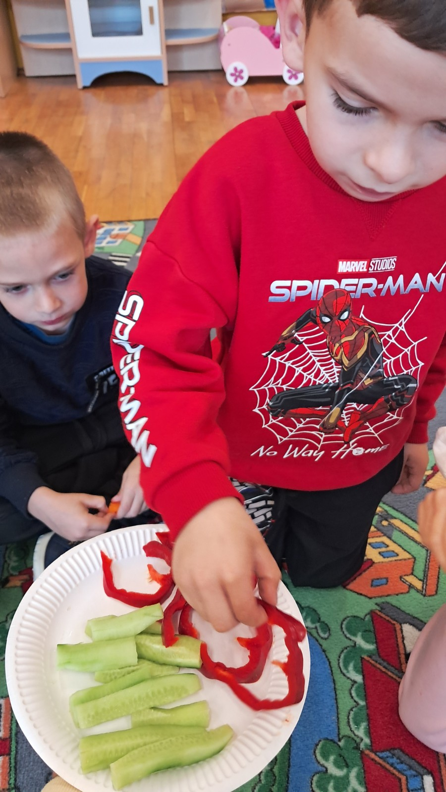 Dzieci jedzą warzywa.