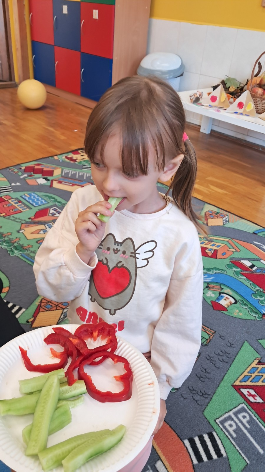 Dzieci jedzą warzywa.