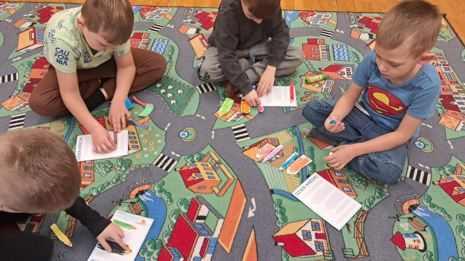 Dzieci wykonują zadanie artystyczne.