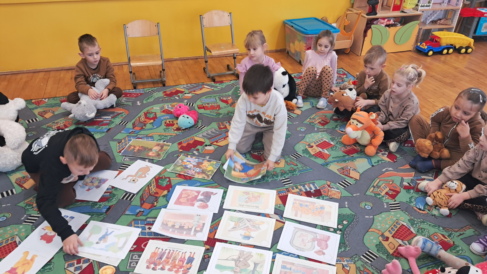 Dzieci słuchają historii o pluszowym misiu.