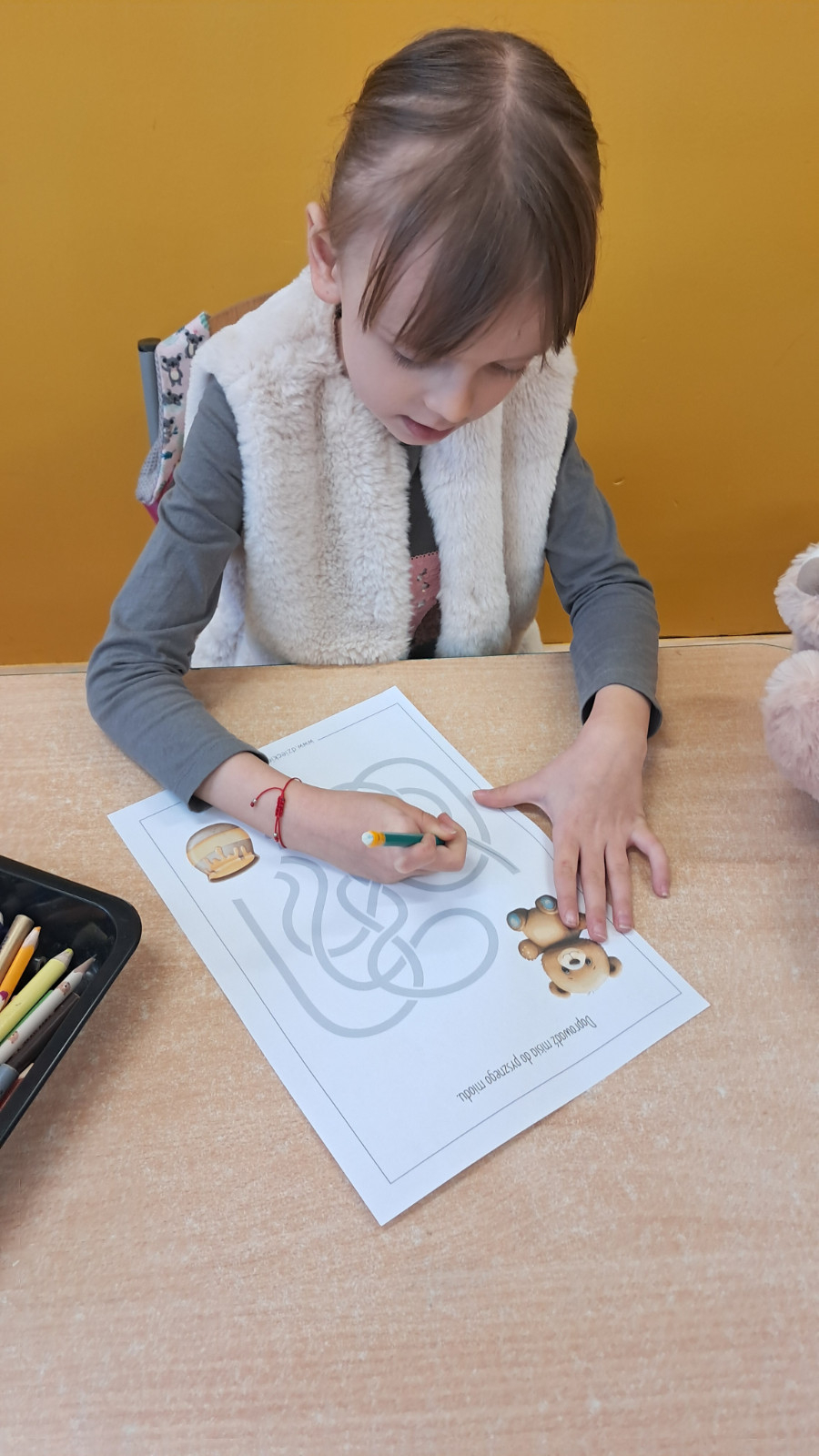 Dziecko wykonuje misiowe karty pracy.