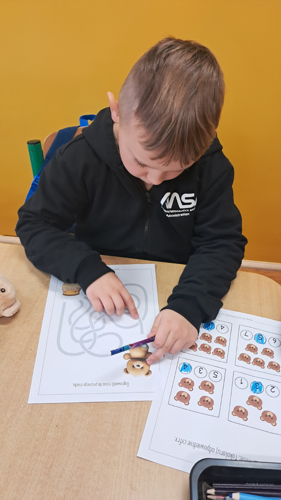 Dziecko wykonuje misiowe karty pracy.