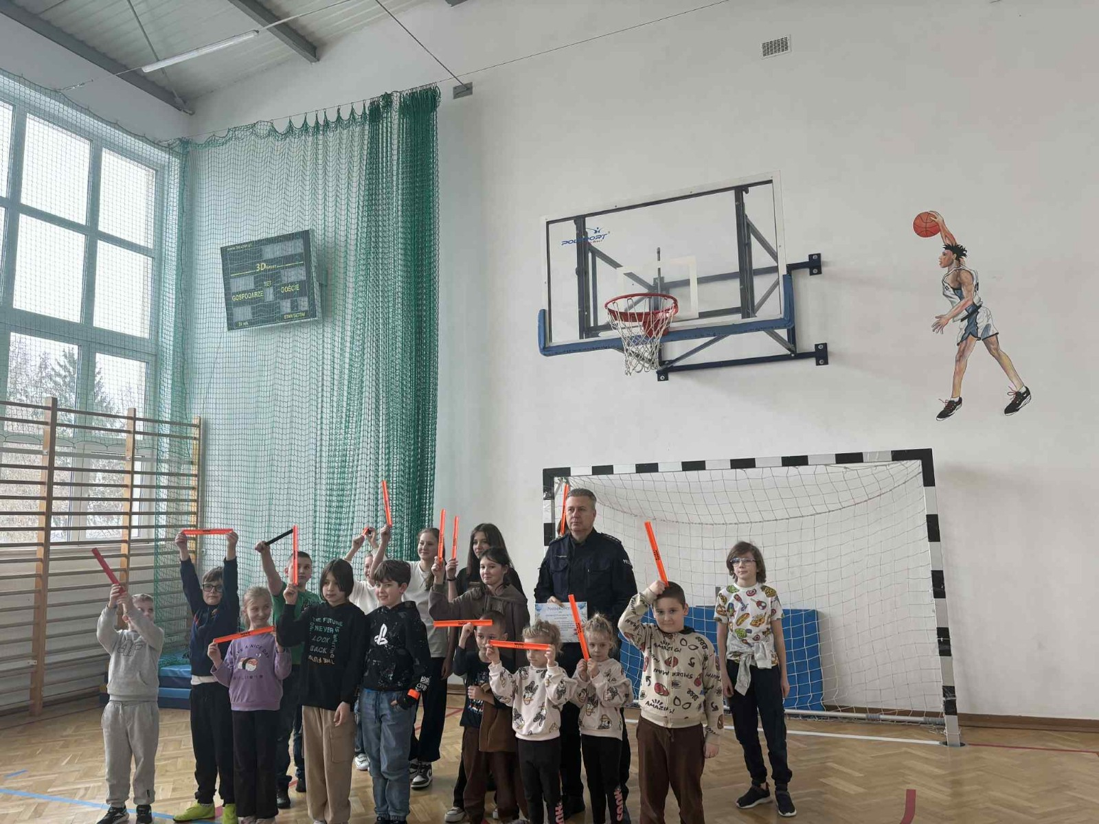 Policjant przekazuje społeczności szkolnej informacje na temat bezpieczeństwa podczas jazdy spacerów oraz ferii zimowych.