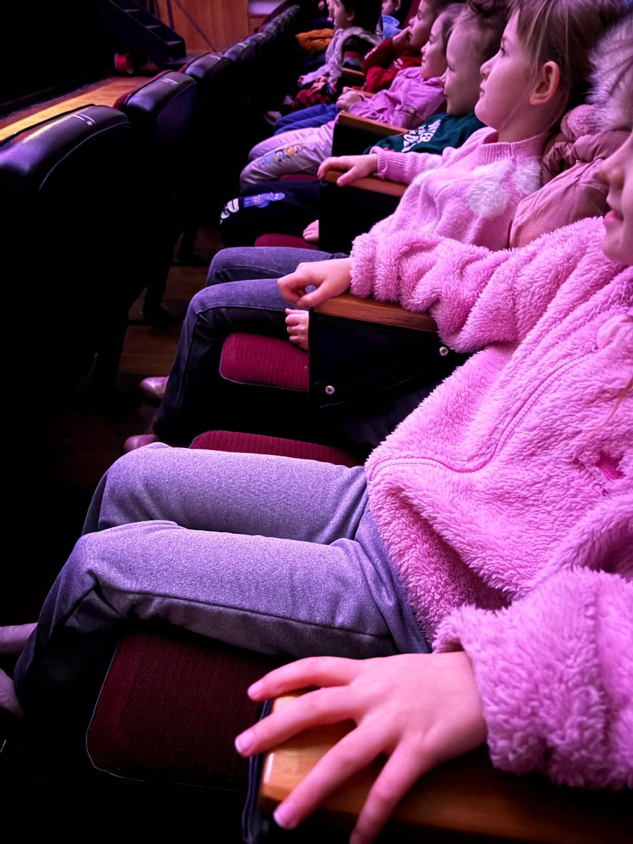 Dzieci ze skupieniem oglądają spektakl.