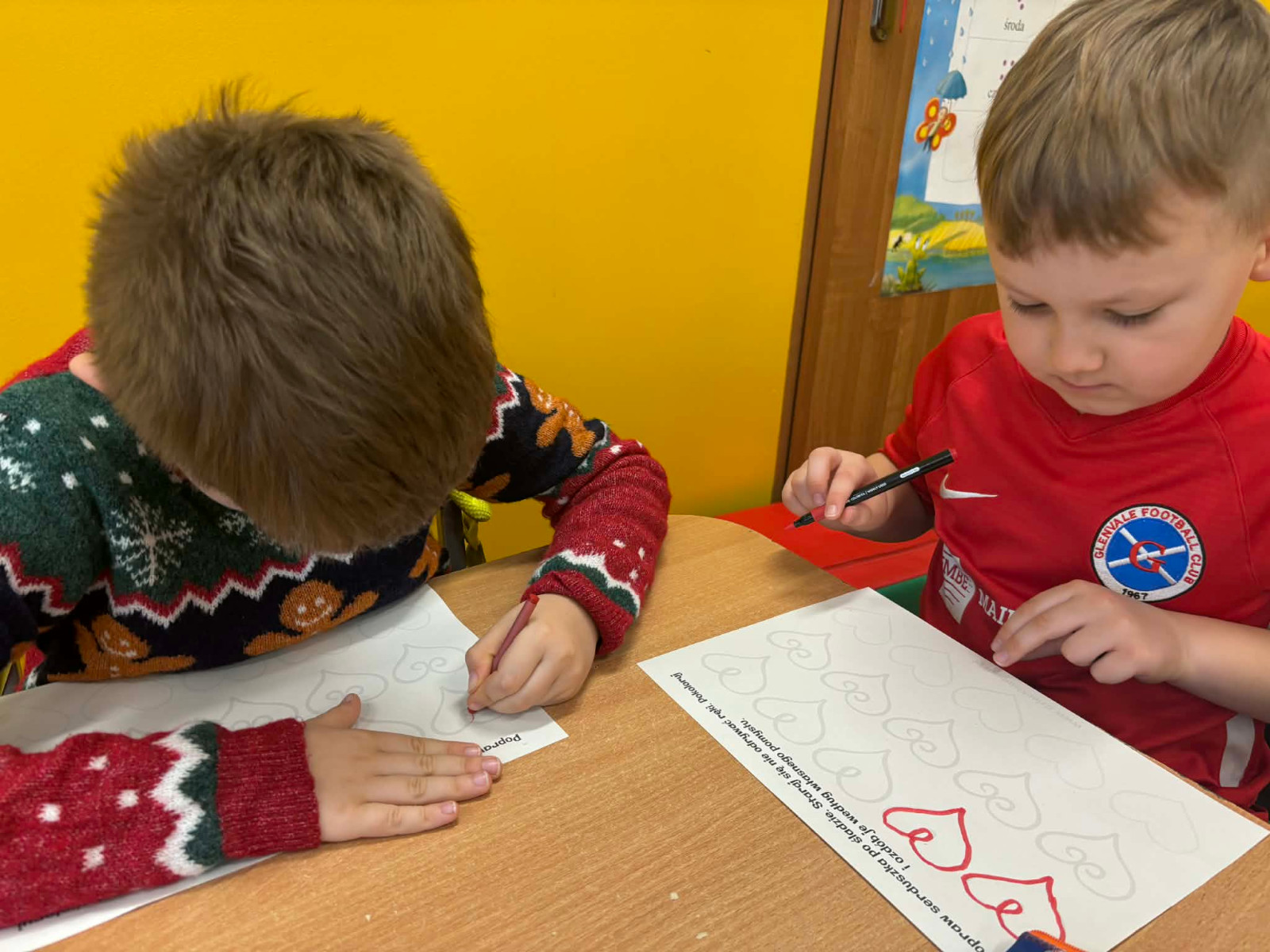 Dzieci kolorują serca.