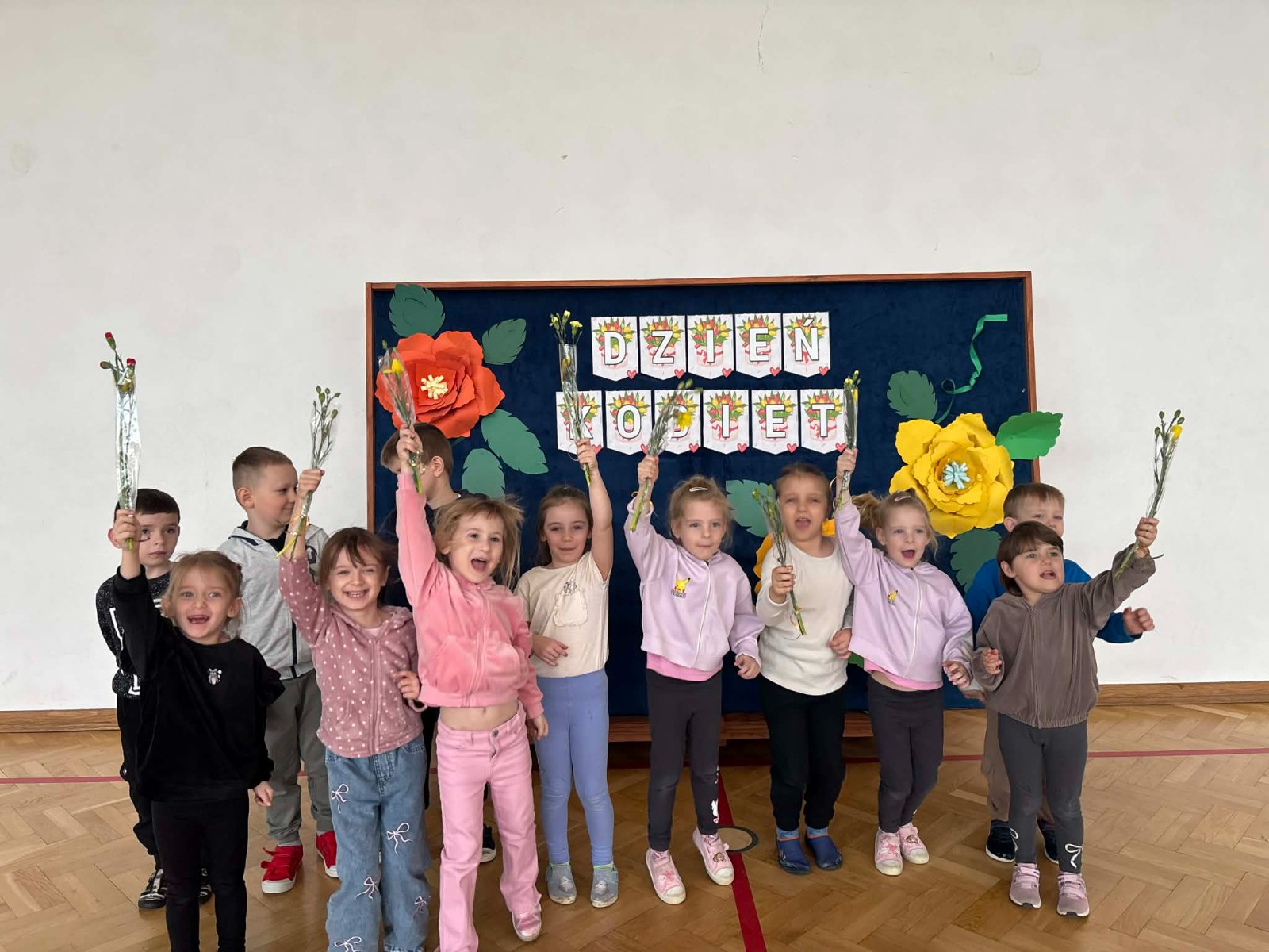 Dzieci pozują do zdjęcia w radosnym nastroju.