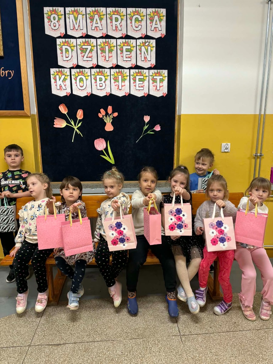 Dzieci pozują do zdjęcia w radosnym nastroju.