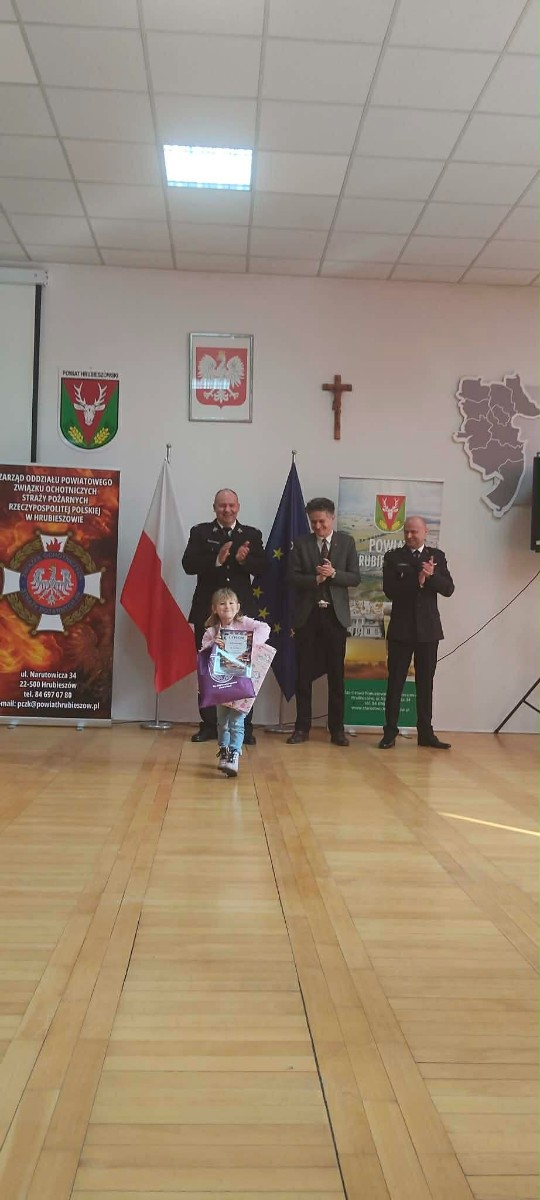 Dziecko prezentuje się z dyplomem.