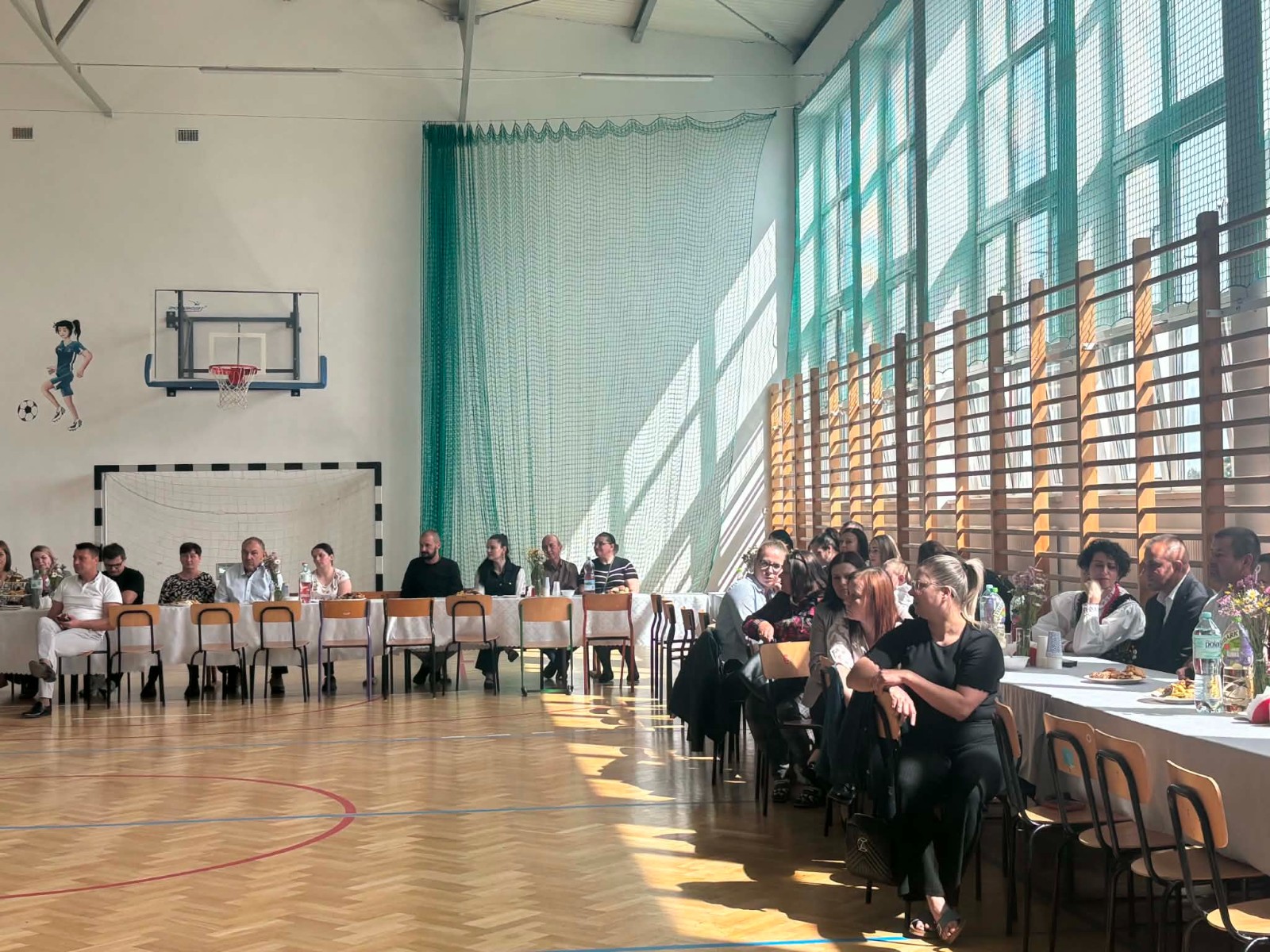 Przy stołach siedzą zebrani goście
