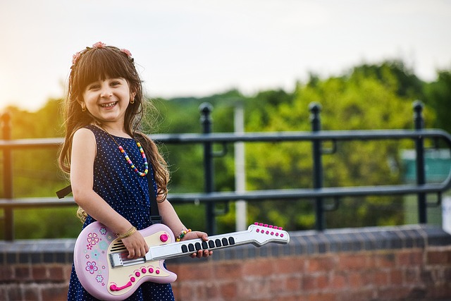 Grafika ilustrująca dziewczynkę z gitarą