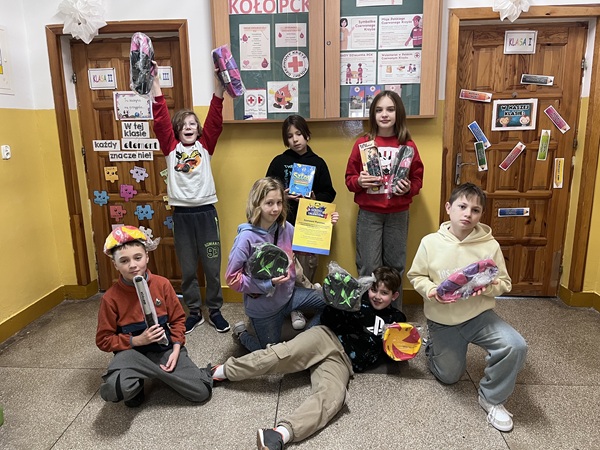 Grafika ilustrująca uczniów trzymających nagrody