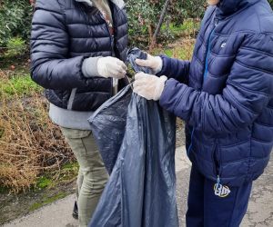 Uczniowie klasy 4 i 7 wspólnie zbierają śmieci na terenie wokół szkoły
