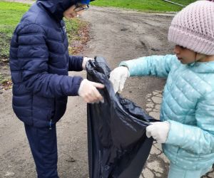 Uczniowie klasy 4 sprzątają teren wokół szkoły