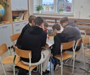Dzień Życzliwości z planszówkami – uczniowie klasy ósmej grają z czwartoklasistami przy stoliku