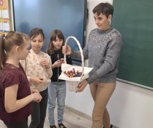 Jedna z mam z Rady Rodziców rozdaje dzieciom słodki poczęstunek