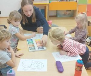 Zabawy integracyjne dla najmłodszych – uczennica klasy szóstej rysuje z przedszkolakami
