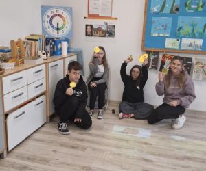 Uczniowie klasy szóstej i siódmej z uśmiechami wręczonymi przez młodszych kolegów