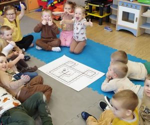 Przedszkolaki siedzą wokół gotowej trasy dla Ozobota