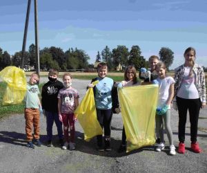 Grupa ośmiorga uczniów z wypełnionymi workami na śmieci