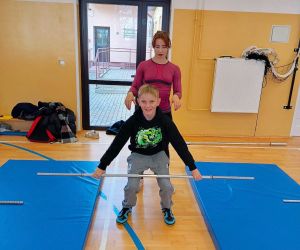 Uczeń podnosi sztangę pod okiem trenerki