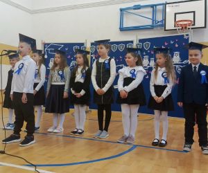 Jeden z uczniów przy mikrofonie przed grupą pozostałych pierwszoklasistów