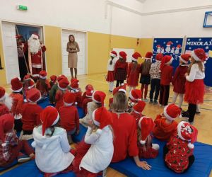 Święty Mikołaj wchodzi do sali gimnastycznej i wita zgromadzone dzieci