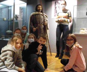 Uczniowie klasy IV przy manekinie ubranym w strój z czasów starożytności