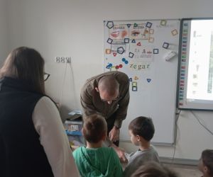 Leśnik prezentuje dzieciom plansze przyrodnicze