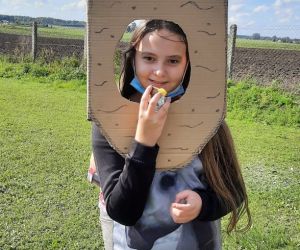 Uczennica przebrana za ziemniaka stoi na boisku szkolnym