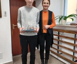 Uczeń - laureat konkursu odbiera nagrodę od pani Dyrektor