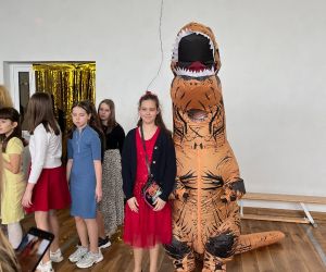 Uczennica z chłopcem przebranym za dinozaura