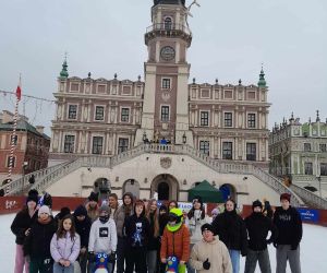 Uczniowie na lodowisku na tle ratusza w Zamościu