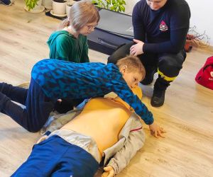 Uczeń klasy trzeciej sprawdza czynności życiowe na fantomie