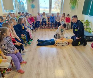 Uczeń klasy drugiej wykonuje masaż serca na fantomie