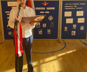 Uczeń stoi przy mikrofonie