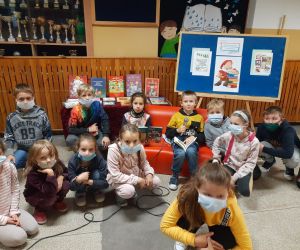 Dzieci wsłuchują się w czytane przez nauczyciela książki