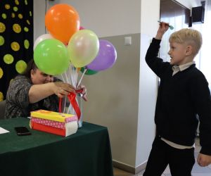 na zdjęciu widoczny jest chłopiec przebijający balon.